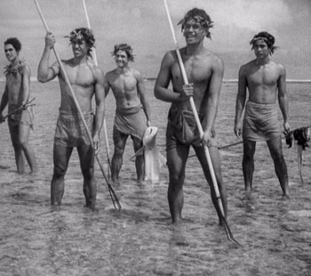 Movie still from “Tabu: A Story of the South Seas” (1931), directed by F.W. Murnau – A black and white photo of a group of men standing in the water; Medium shot, High angle