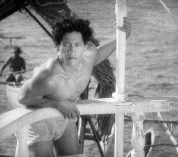 Movie still from “Tabu: A Story of the South Seas” (1931), directed by F.W. Murnau – A man leaning on a railing on a boat; Medium shot, Low angle