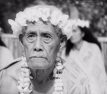 Movie still from “Tabu: A Story of the South Seas” (1931), directed by F.W. Murnau – An older man wearing a lei and a hawaiian shirt; Close Up shot, Over the shoulder angle
