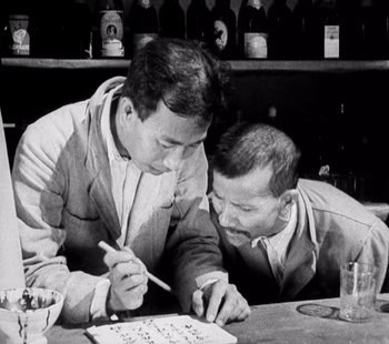 Movie still from “Tabu: A Story of the South Seas” (1931), directed by F.W. Murnau – A couple of men sitting at a table with a drink; Close Up shot, High angle