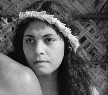 Movie still from “Tabu: A Story of the South Seas” (1931), directed by F.W. Murnau – A woman with a flower in her hair is posing for a picture; Close Up shot, Over the shoulder angle