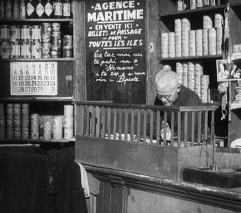 Movie still from “Tabu: A Story of the South Seas” (1931), directed by F.W. Murnau – An old man working in a store in a market place; Wide shot, High angle