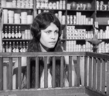 Movie still from “Tabu: A Story of the South Seas” (1931), directed by F.W. Murnau – A young woman in a store looking at the camera; Medium shot, High angle