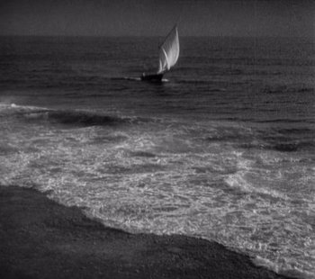 Movie still from “Tabu: A Story of the South Seas” (1931), directed by F.W. Murnau – A sailboat in the ocean on a cloudy day; Extreme Wide shot, High angle