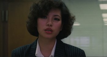 Movie still from “Taipei Story” (1985), directed by Edward Yang – A young woman with short curly hair wearing a white shirt; Close Up shot, Over the shoulder angle