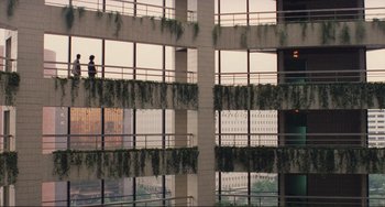 Movie still from “Taipei Story” (1985), directed by Edward Yang – A man standing on a balcony looking out of a building; Extreme Wide shot, High angle
