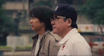 Movie still from “Taipei Story” (1985), directed by Edward Yang – Two men standing next to each other on a street; Close Up shot, Low angle