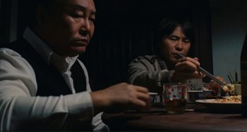 Movie still from “Taipei Story” (1985), directed by Edward Yang – Two people sitting at a table with drinks; Medium shot, Over the shoulder angle