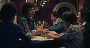 Movie still from “Taipei Story” (1985), directed by Edward Yang – A group of people sitting at a table with drinks; Medium shot, Over the shoulder angle