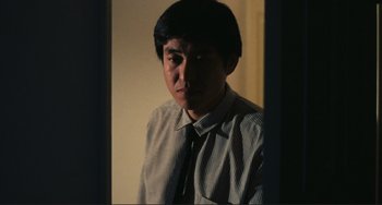 Movie still from “Taipei Story” (1985), directed by Edward Yang – A man wearing a shirt and a tie looking into a mirror; Close Up shot, Low angle
