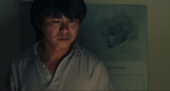 Movie still from “Taipei Story” (1985), directed by Edward Yang – A man standing in front of a picture of a woman; Close Up shot, Low angle