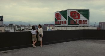 Movie still from “Taipei Story” (1985), directed by Edward Yang – Two women standing on the side of a building looking at each other; Extreme Wide shot, Low angle