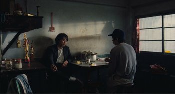Movie still from “Taipei Story” (1985), directed by Edward Yang – Two men are sitting at a table in a restaurant; Medium shot, Over the shoulder angle