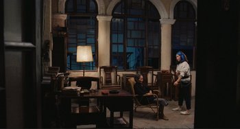 Movie still from “Taipei Story” (1985), directed by Edward Yang – Two people sitting in chairs in a living room; Wide shot, High angle