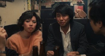 Movie still from “Taipei Story” (1985), directed by Edward Yang – A man and a woman sitting at a dinner table; Medium shot, High angle