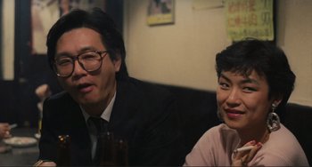 Movie still from “Taipei Story” (1985), directed by Edward Yang – A man and a woman sitting next to each other at a table; Close Up shot, Low angle