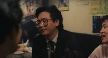 Movie still from “Taipei Story” (1985), directed by Edward Yang – A man wearing a suit and glasses sitting at a table; Close Up shot, Over the shoulder angle