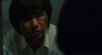 Movie still from “Taipei Story” (1985), directed by Edward Yang – A woman in a white shirt is looking at the camera; Close Up shot, Over the shoulder angle