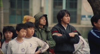 Movie still from “Taipei Story” (1985), directed by Edward Yang – A group of young men standing next to each other; Medium shot, Low angle