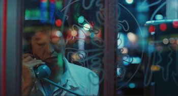 Movie still from “Taipei Story” (1985), directed by Edward Yang – A man talking on a phone in front of a window; Close Up shot, High angle