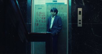 Movie still from “Taipei Story” (1985), directed by Edward Yang – A man standing in front of an elevator; Medium shot, Low angle