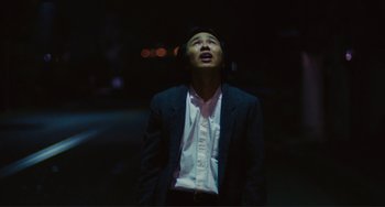 Movie still from “Taipei Story” (1985), directed by Edward Yang – A man standing in the dark looking up at the sky; Medium shot, Low angle