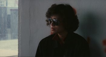 Movie still from “Taipei Story” (1985), directed by Edward Yang – A person wearing sunglasses and a black shirt; Close Up shot, Over the shoulder angle