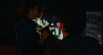 Movie still from “Taipei Story” (1985), directed by Edward Yang – A woman holding a cat in front of a man in the dark; Medium shot, Over the shoulder angle