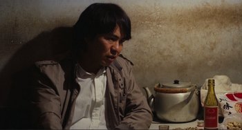 Movie still from “Taipei Story” (1985), directed by Edward Yang – A man sitting in front of a tea pot; Close Up shot, High angle