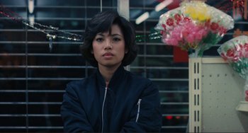 Movie still from “Taipei Story” (1985), directed by Edward Yang – A woman in a black jacket sitting in front of a window; Close Up shot, Over the shoulder angle