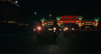 Movie still from “Taipei Story” (1985), directed by Edward Yang – A group of people riding motorcycles down a street at night; Extreme Wide shot, Low angle