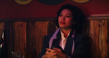Movie still from “Taipei Story” (1985), directed by Edward Yang – A woman sitting down with her hands clasped together; Medium shot, High angle