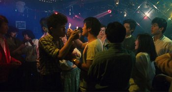 Movie still from “Taipei Story” (1985), directed by Edward Yang – A group of young men standing around each other; Medium shot, High angle