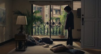 Movie still from “Taipei Story” (1985), directed by Edward Yang – A person standing in a living room near a window; Wide shot, High angle