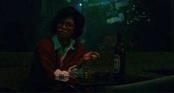 Movie still from “Taipei Story” (1985), directed by Edward Yang – A woman sitting at a table with a glass of wine; Medium shot, High angle