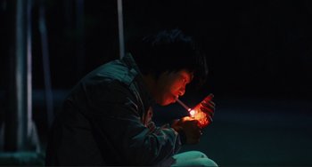 Movie still from “Taipei Story” (1985), directed by Edward Yang – A person lighting a cigarette in the dark; Medium shot, Low angle