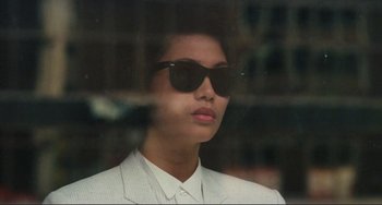 Movie still from “Taipei Story” (1985), directed by Edward Yang – A woman wearing a white suit and black sunglasses; Close Up shot, Low angle