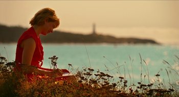 Movie still from “Take This Waltz” (2011), directed by Sarah Polley – A woman sitting on the grass near the water; Wide shot, High angle