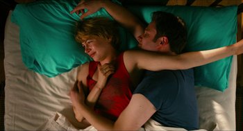 Movie still from “Take This Waltz” (2011), directed by Sarah Polley – A man and a woman laying in bed together; Medium shot, Overhead angle