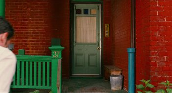 Movie still from “Take This Waltz” (2011), directed by Sarah Polley – A green front door of a brick house; Wide shot, High angle