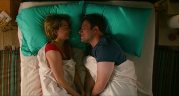 Movie still from “Take This Waltz” (2011), directed by Sarah Polley – A man and a woman laying in a bed together; Medium shot, Overhead angle