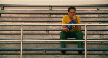 Movie still from “Take This Waltz” (2011), directed by Sarah Polley – A man sitting on some steps eating something; Wide shot, High angle