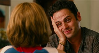 Movie still from “Take This Waltz” (2011), directed by Sarah Polley – A man sitting in front of a woman with his hand on his face; Close Up shot, Over the shoulder angle