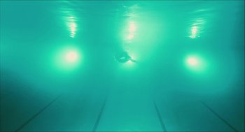 Movie still from “Take This Waltz” (2011), directed by Sarah Polley – A person swimming in a swimming pool under water; Extreme Wide shot, Overhead angle
