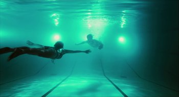 Movie still from “Take This Waltz” (2011), directed by Sarah Polley – Two people are swimming in a swimming pool; Extreme Wide shot, Overhead angle