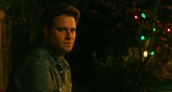 Movie still from “Take This Waltz” (2011), directed by Sarah Polley – A young man is looking at the camera while standing in the dark; Close Up shot, Over the shoulder angle