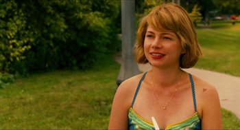 Movie still from “Take This Waltz” (2011), directed by Sarah Polley – A woman in a colorful dress smiling for the camera; Close Up shot, Over the shoulder angle