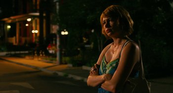 Movie still from “Take This Waltz” (2011), directed by Sarah Polley – A woman standing on the side of the street at night; Medium shot, Over the shoulder angle