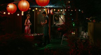 Movie still from “Take This Waltz” (2011), directed by Sarah Polley – A man and a woman standing in a room with lights; Wide shot, High angle