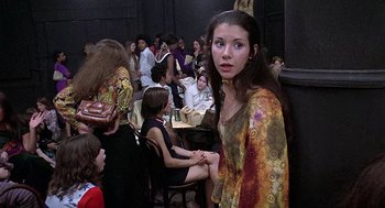 Movie still from “Taking Off” (1971), directed by Milos Forman – A woman standing in front of a group of people; Medium shot, High angle